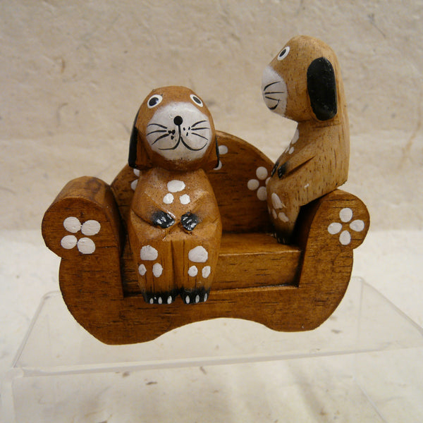 Two Dogs Sitting on Natural Wood Sofa decorated with Flowers