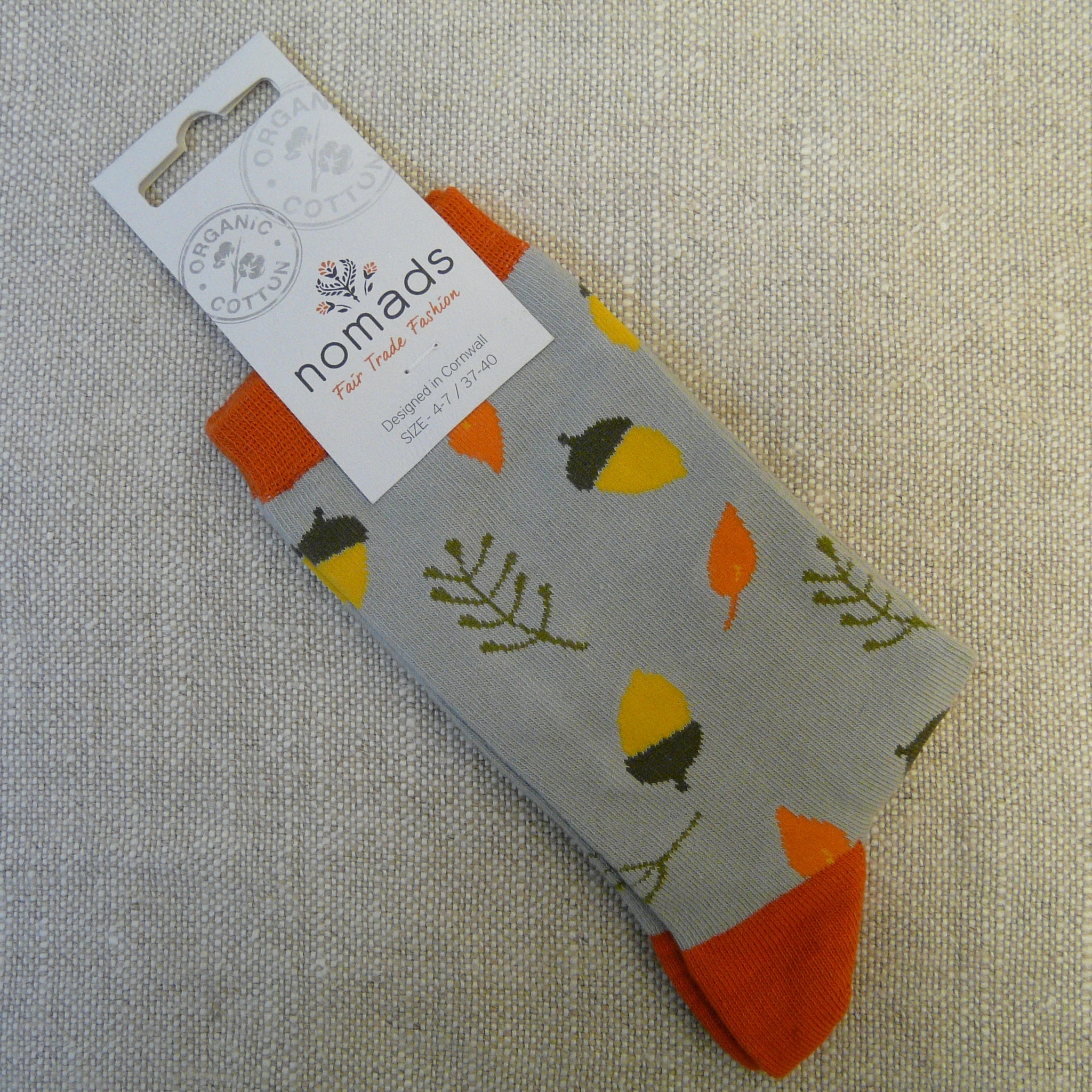 P1130727-Organic-Cotton-socks-4-7-Acorn-on-grey-front.-Grey-socks-decorated-with-yellow-acorns-in-brown-cups,-pale-orange-leaves-and-pale-olive-green-fronds.-Orange-heals-orange-stretch-tops.