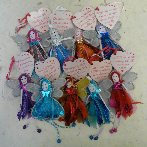 Nine glitter quote fairies feature in the picture Eight have dress made of strips of colour co-ordinated sparkly ribbon Each fairy has smiling face eyes and sequined hair